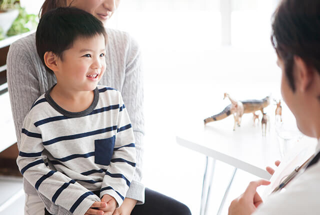 子どもの診察を行う男性医師