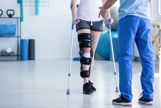 リハビリを行う松葉杖の女性と理学療法士