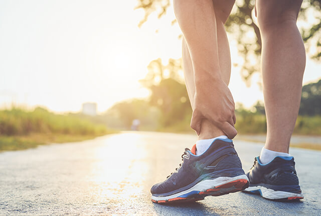 左足首を左手でおさえる男性