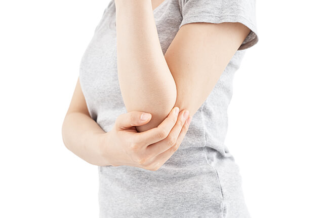 左肘を右手でおさえる女性