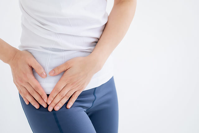 右太ももを両手でおさえる女性