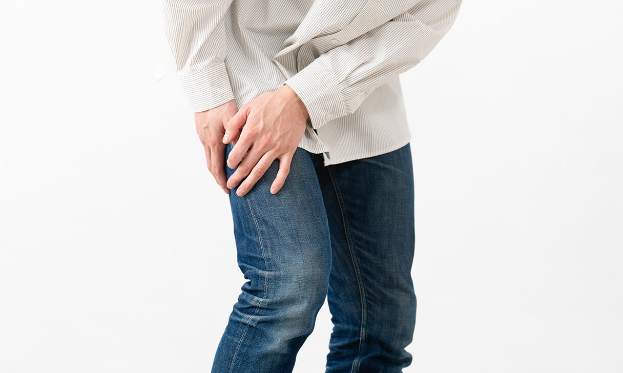 右太ももを両手でおさえる男性